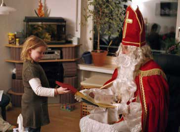 Der Nikolaus übergibt ein Geschenk
